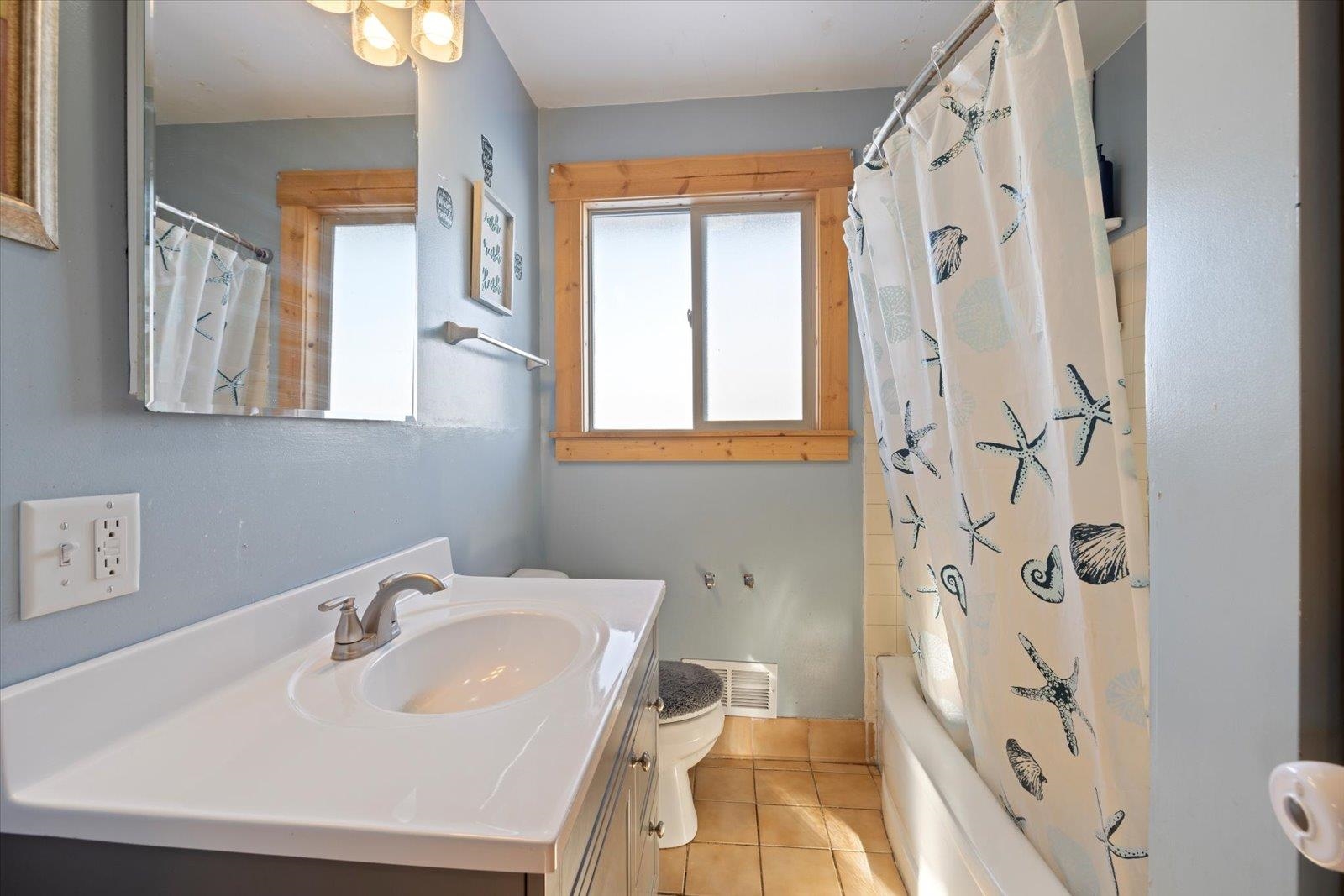 24 Fern Court Babbitt, MN 55706 - Photo 24 of 41 Bathroom featuring vanity, light tile patterned floors, and shower / bathtub combination with curtain