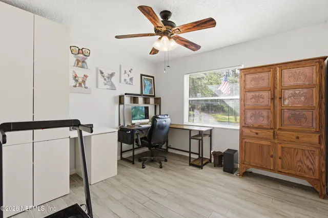 a view of a workspace with furniture and a window