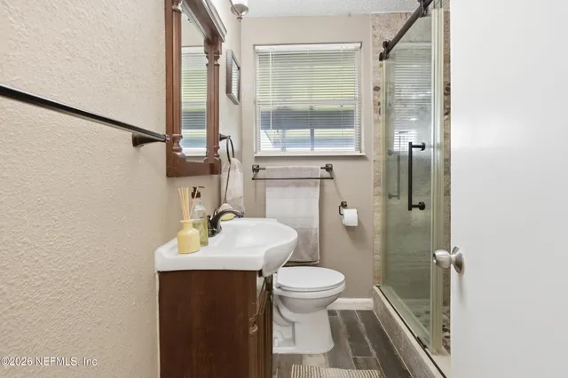 a bathroom with a toilet sink and mirror