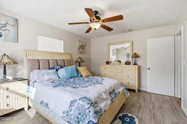 a bedroom with a bed a chandelier and a dresser