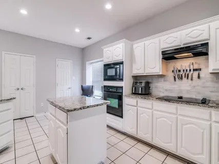a kitchen with stainless steel appliances granite countertop a sink and a stove