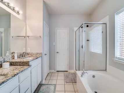 a bathroom with a granite countertop sink a mirror and a bathtub