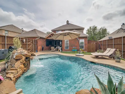 a view of a house with swimming pool and furniture