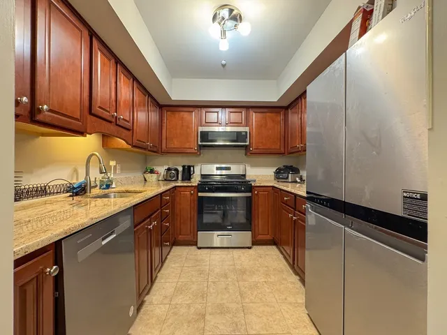 a kitchen with stainless steel appliances granite countertop a stove sink and cabinets