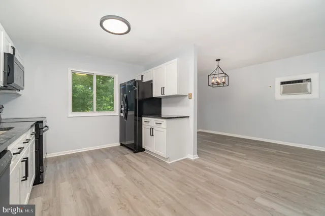 a view of a kitchen with a stove wooden floor and a window
