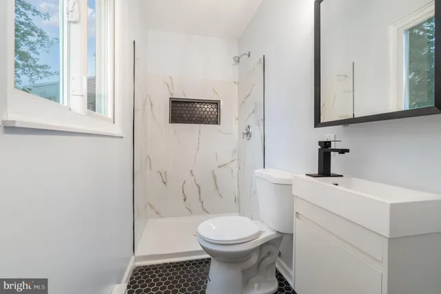 a bathroom with a toilet a sink a vanity and mirror