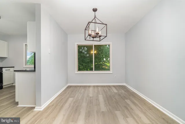 a view of a room with wooden floor exposed radiator and windows