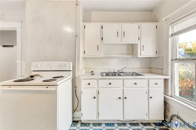 a kitchen with white cabinets and white appliances