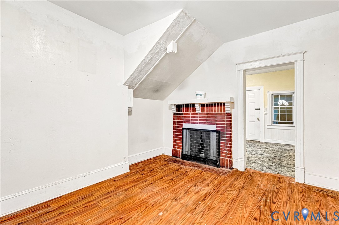 3301 Main Street Petersburg, VA 23803 - Photo 2 of 18 a view of an empty room with wooden floor fireplace and a window