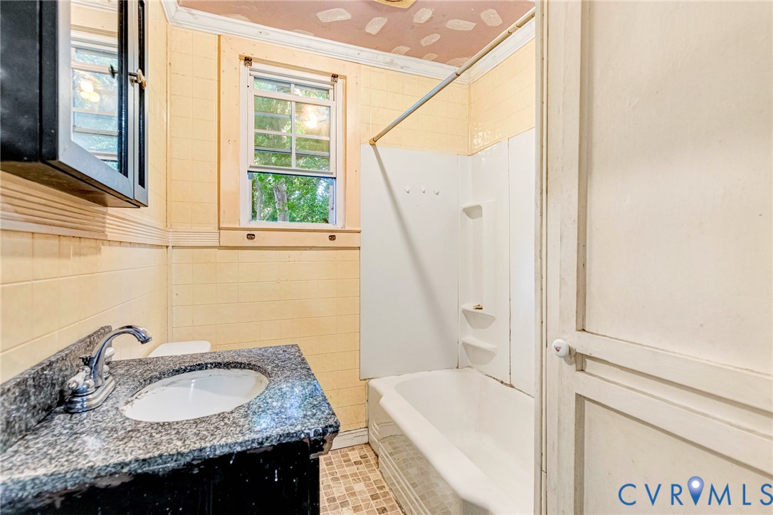 3301 Main Street Petersburg, VA 23803 - Photo 6 of 18 a bathroom with a granite countertop sink and a mirror