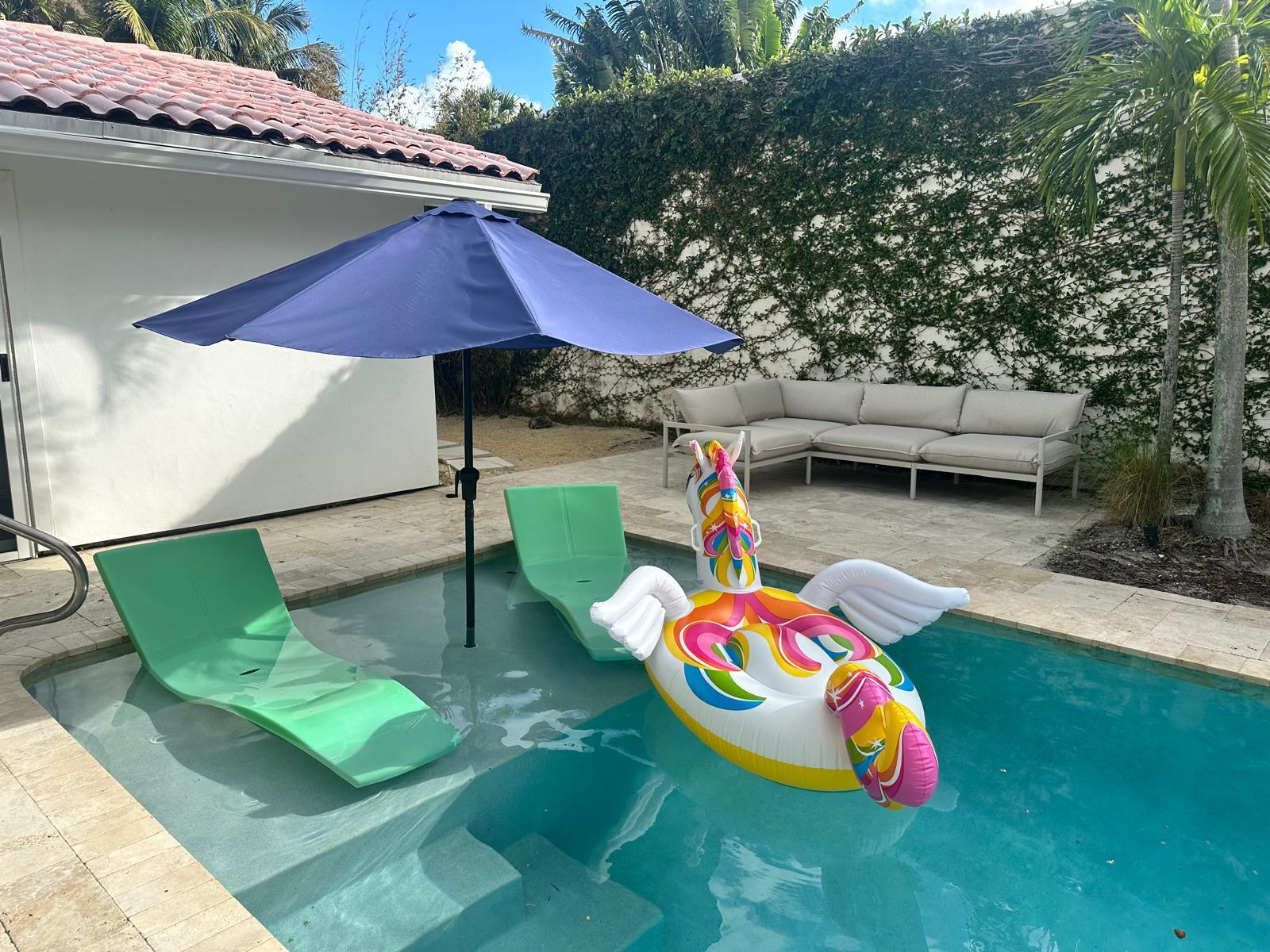 Undisclosed Address Jupiter, FL 33477 - Photo 103 of 107 a yellow and red umbrella sitting in the middle of a yard
