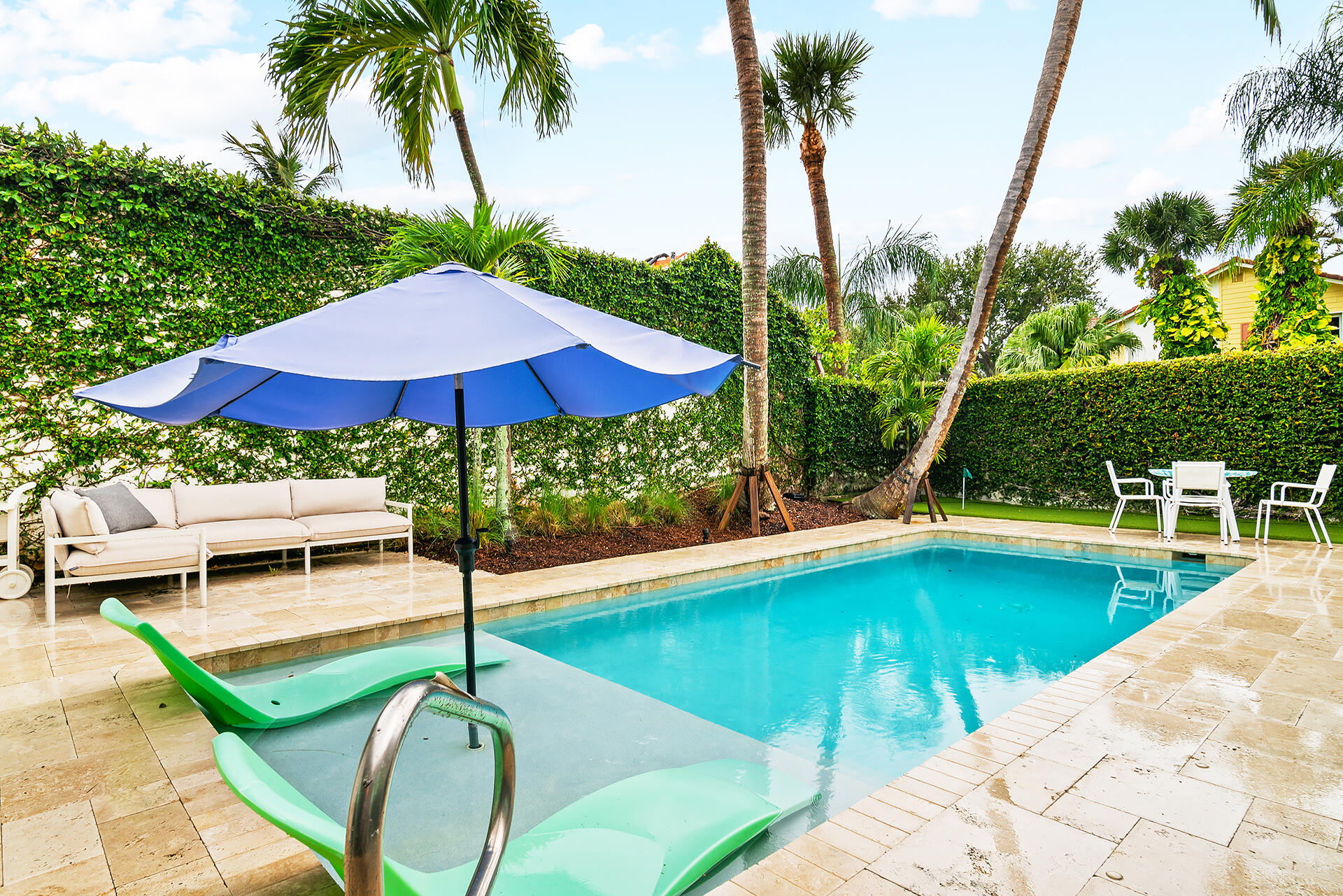 Undisclosed Address Jupiter, FL 33477 - Photo 32 of 107 a view of a swimming pool with a table and chairs under an umbrella