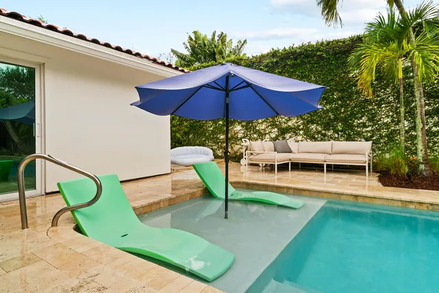 a view of a house with a outdoor space and palm trees