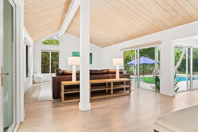 a dining room with furniture a rug and a floor to ceiling window