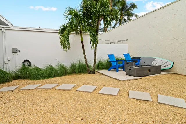 a view of a house with a yard and potted plants