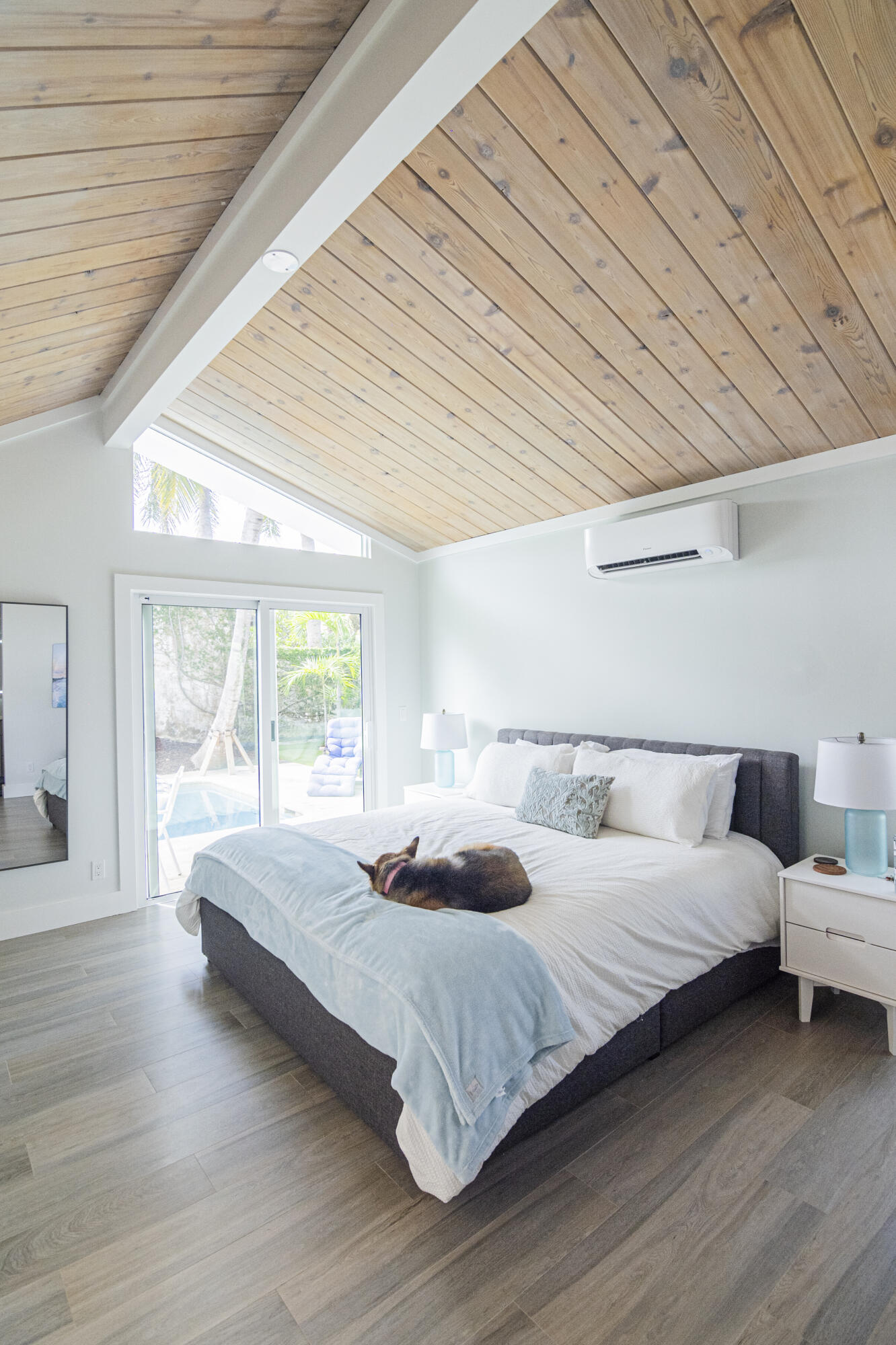 Undisclosed Address Jupiter, FL 33477 - Photo 66 of 107 a bedroom with a bed and a large window with wooden floor