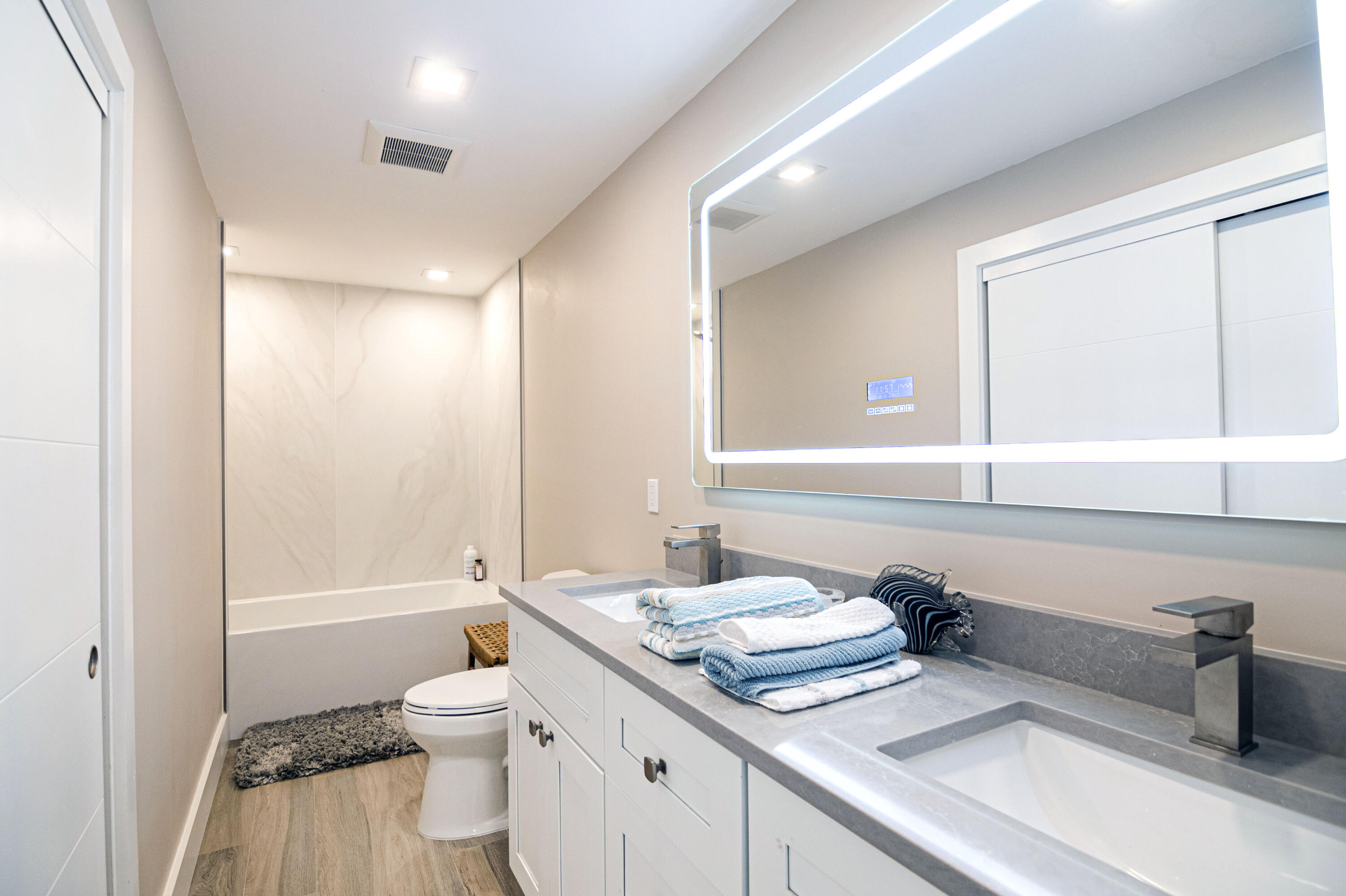 Undisclosed Address Jupiter, FL 33477 - Photo 72 of 107 a bathroom with a sink a toilet and a large mirror