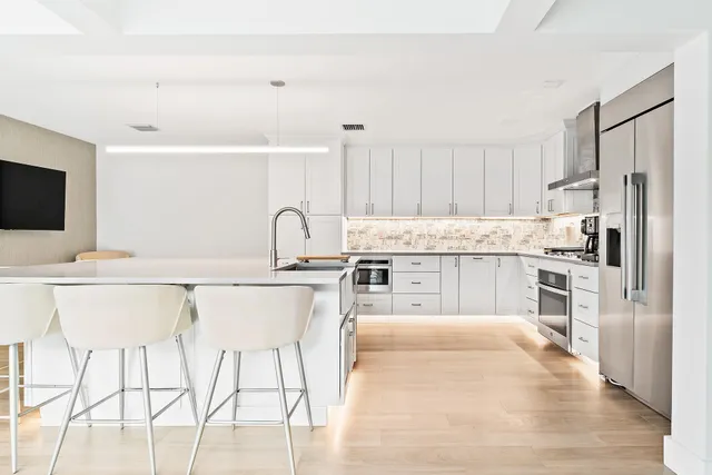 a kitchen with granite countertop a sink cabinets and stainless steel appliances