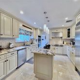 a kitchen with stainless steel appliances kitchen island granite countertop a stove sink and cabinets