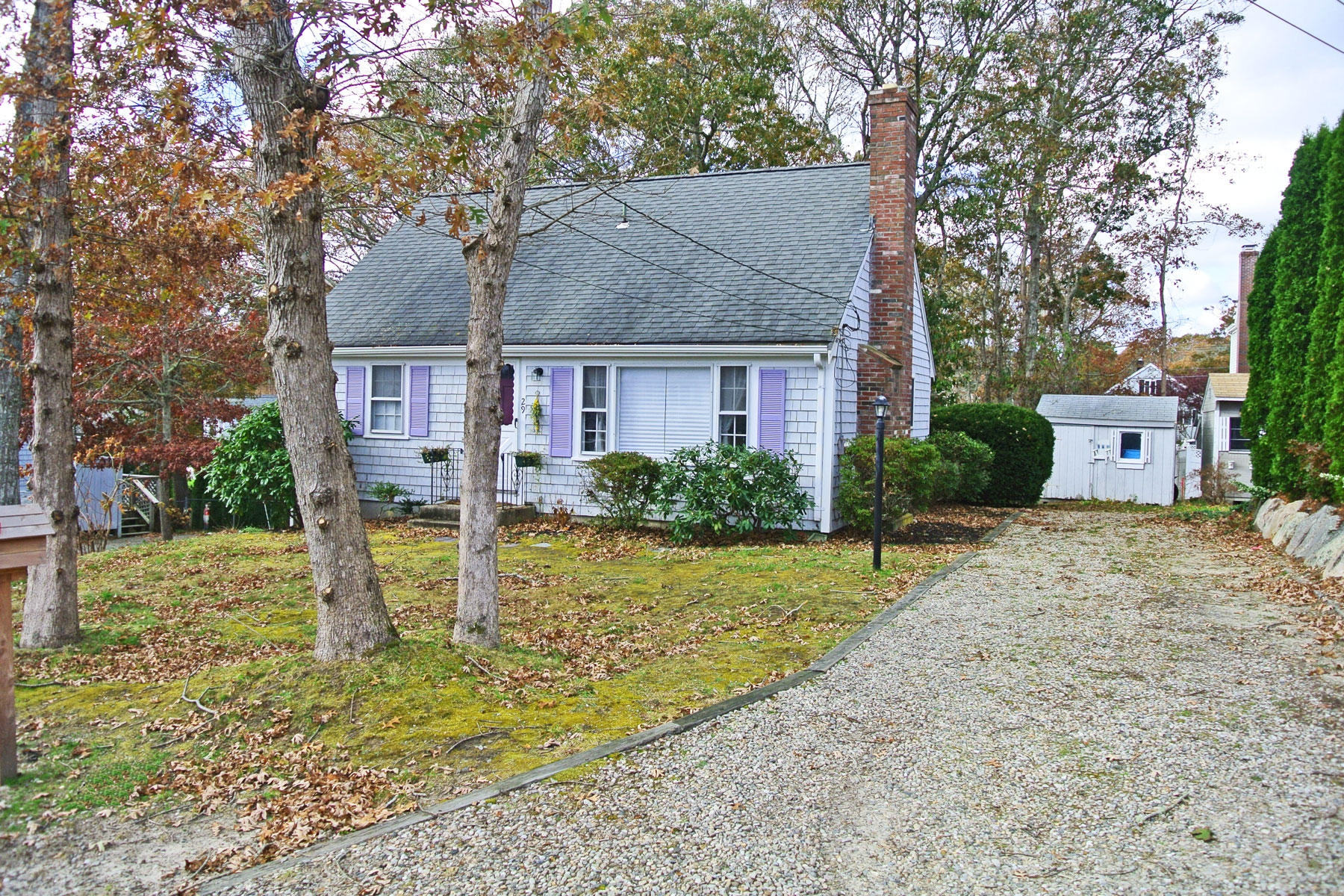 a view of a house with backyard and trees