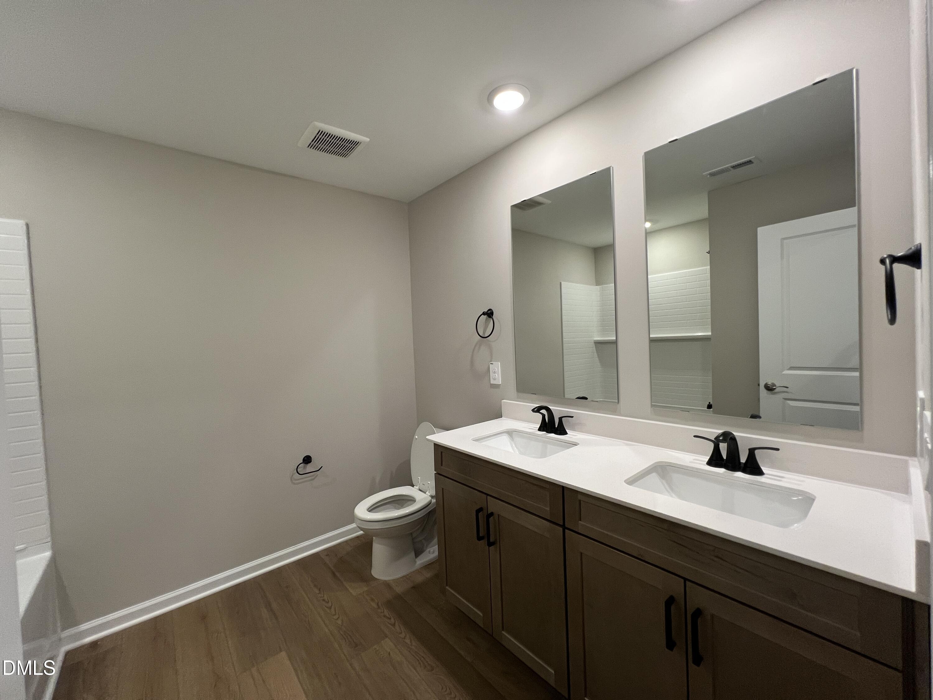 4036 Wesley Chapel Way Raleigh, NC 27616 - Photo 17 of 45 a bathroom with a double vanity sink and a mirror