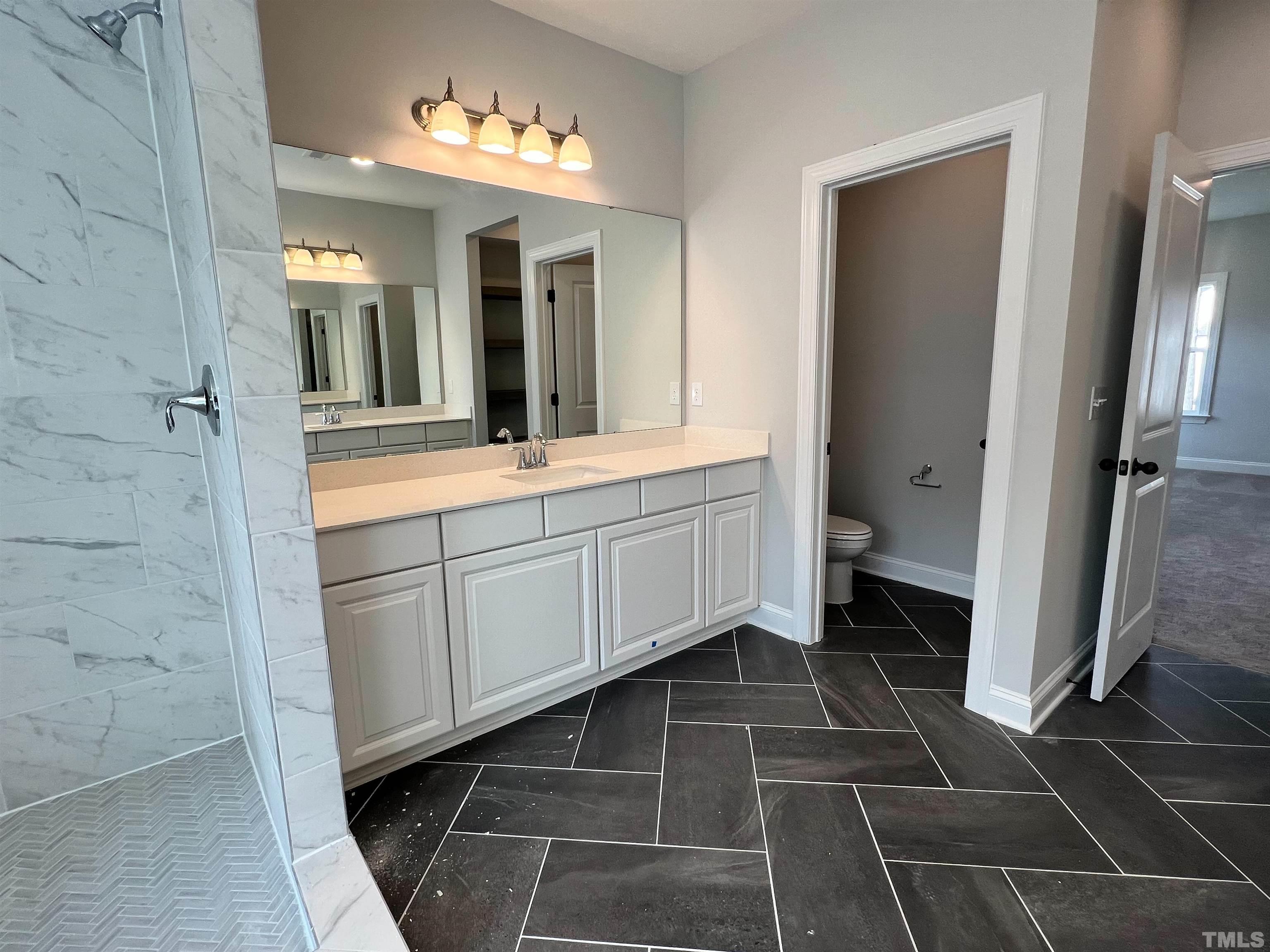 7613 Hasentree Way Wake Forest, NC 27587 - Photo 29 of 39 a bathroom with a double vanity sink and a mirror