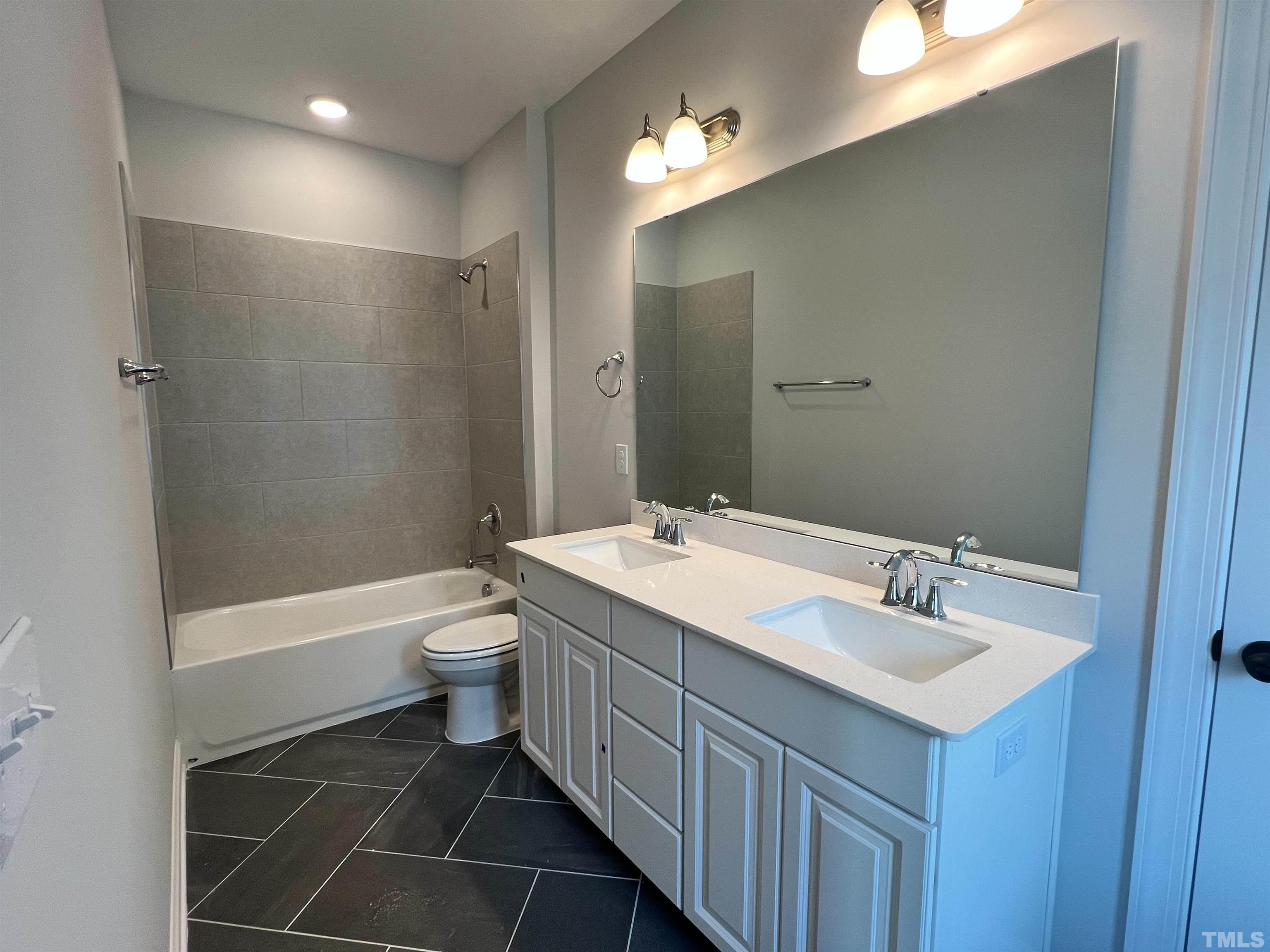 7613 Hasentree Way Wake Forest, NC 27587 - Photo 31 of 39 a bathroom with a double vanity sink mirror toilet and bathtub