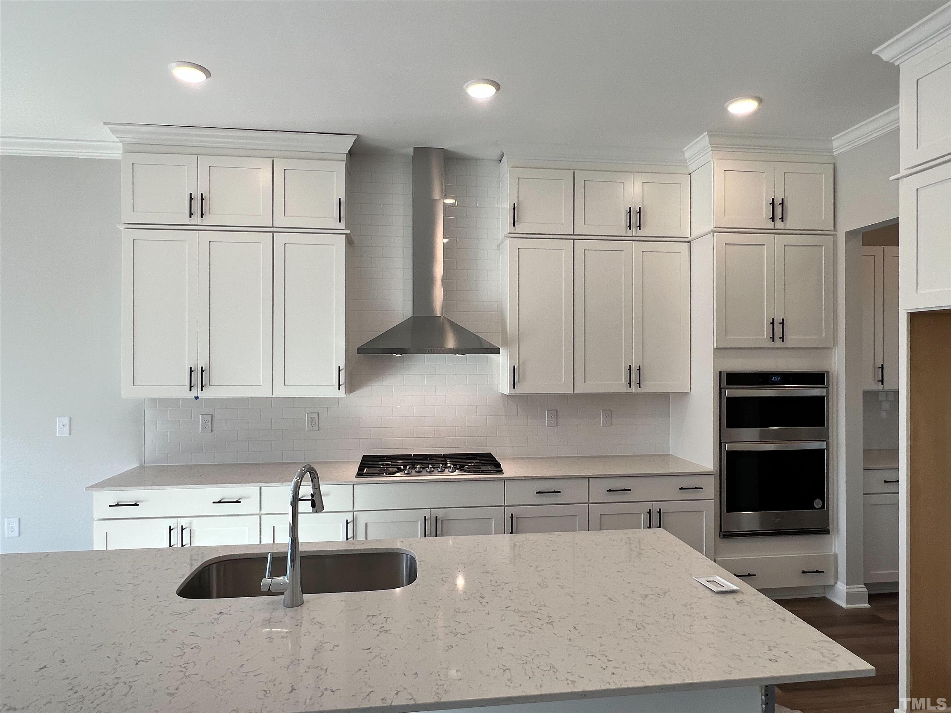 7613 Hasentree Way Wake Forest, NC 27587 - Photo 9 of 39 a kitchen with kitchen island a counter top space and cabinets