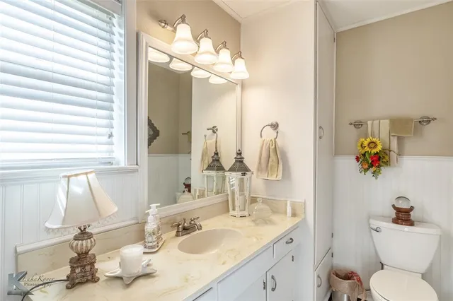 a bathroom with a sink vanity mirror and toilet
