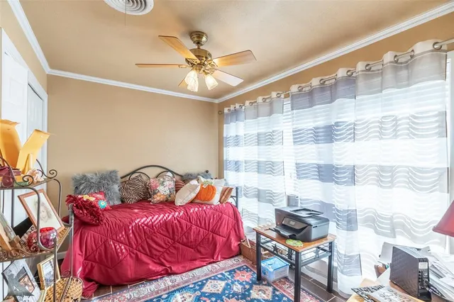 a bedroom with a bed and a chandelier fan