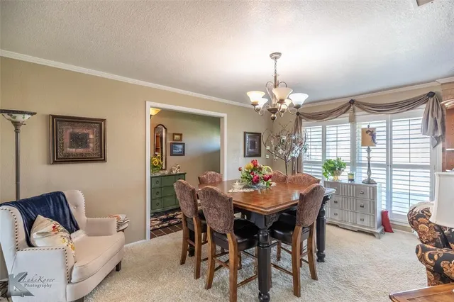 a view of a dining room with furniture and a chandelier