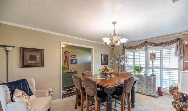 a view of a dining room with furniture and chandelier