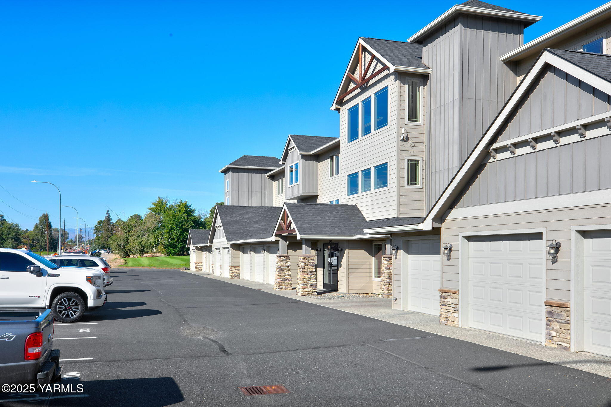 a view of a white house with large windows and a small yard