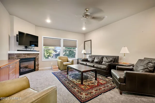 a living room with furniture a fireplace and a flat screen tv
