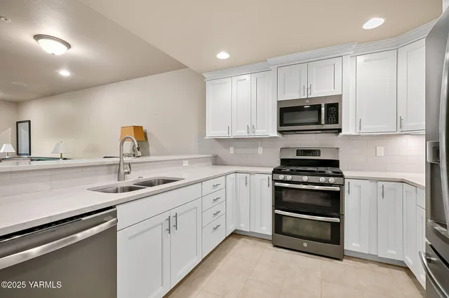 a kitchen with appliances a sink and cabinets
