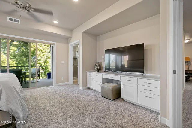 a living room with furniture a flat screen tv and floor to ceiling window