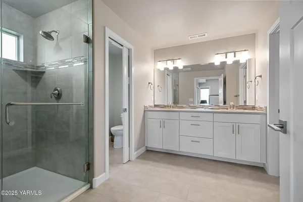 a spacious bathroom with a shower a sink and mirror