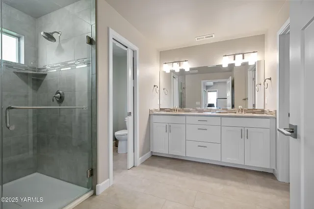 a spacious bathroom with a shower a sink and mirror