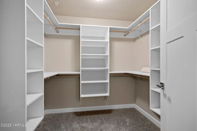 a view of walk in closet with empty racks