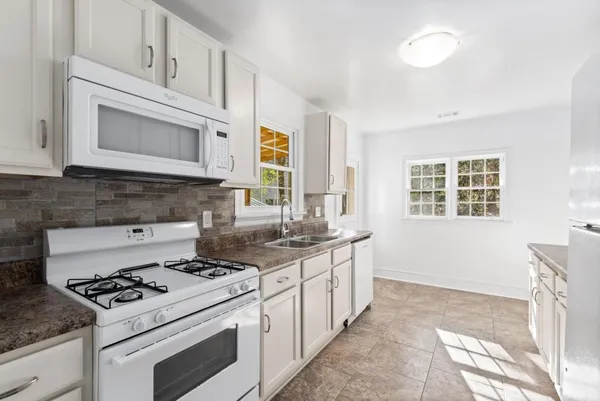 a kitchen with stainless steel appliances white cabinets stove and sink
