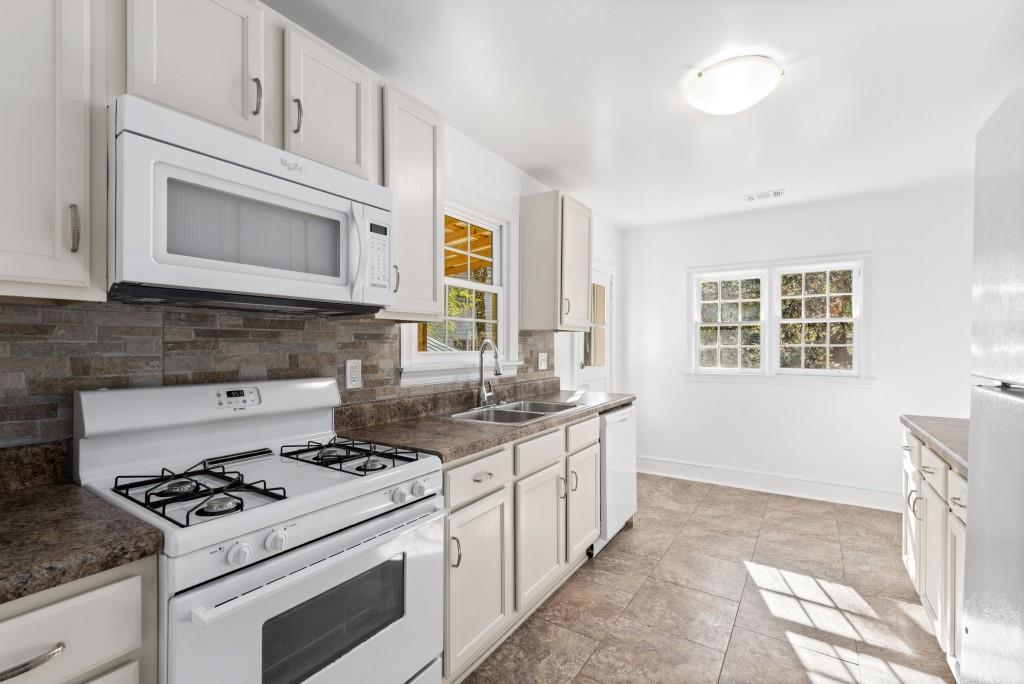 3310 East Roxboro Road Northeast Atlanta, GA 30324 - Photo 11 of 47 a kitchen with stainless steel appliances white cabinets stove and sink