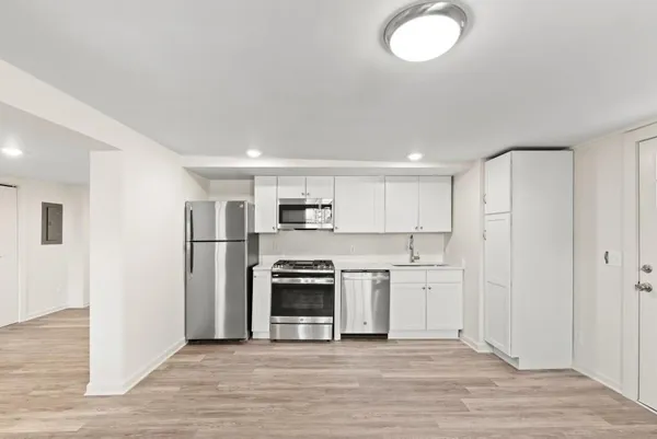 a large kitchen with stainless steel appliances granite countertop a stove and a refrigerator