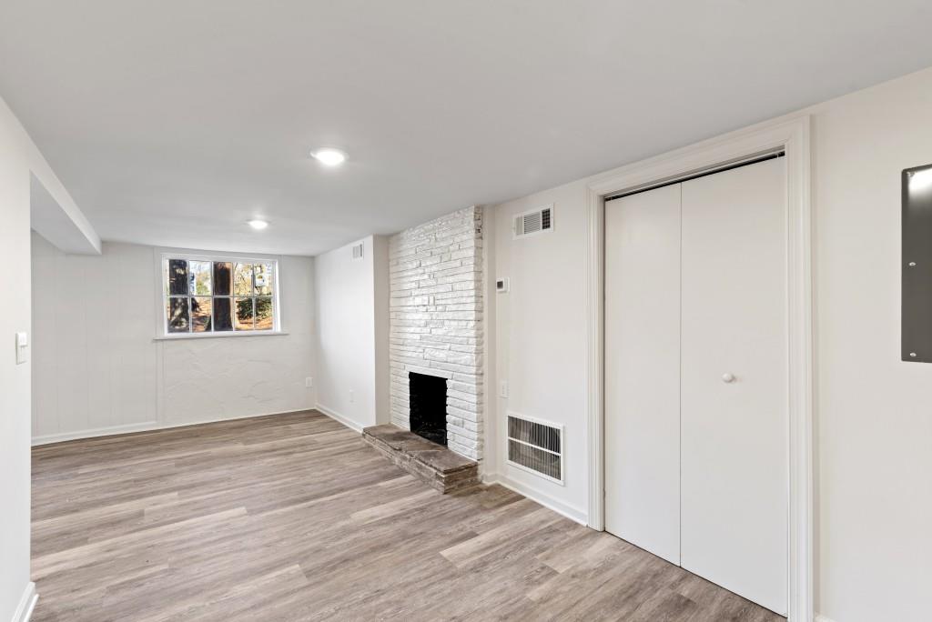 3310 East Roxboro Road Northeast Atlanta, GA 30324 - Photo 26 of 47 a view of empty room with wooden floor and fireplace