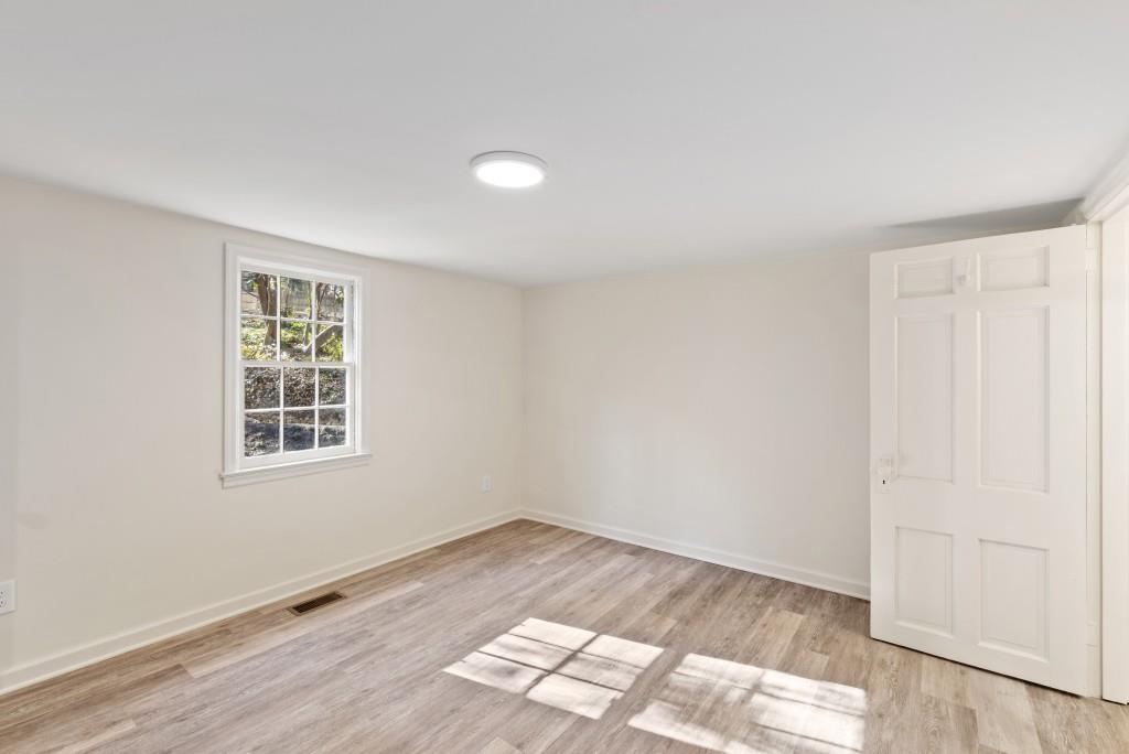 3310 East Roxboro Road Northeast Atlanta, GA 30324 - Photo 31 of 47 an empty room with wooden floor and windows