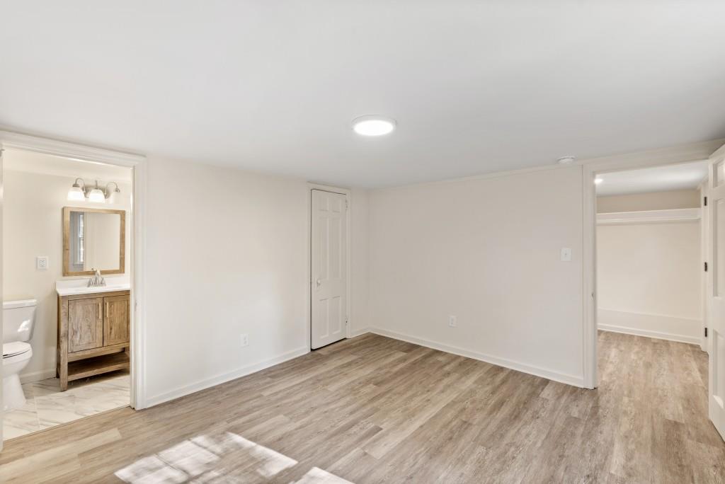 3310 East Roxboro Road Northeast Atlanta, GA 30324 - Photo 32 of 47 an empty room with wooden floor and kitchen