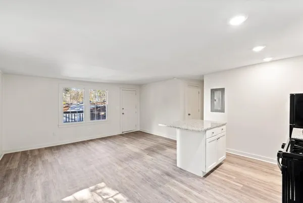 a kitchen with granite countertop a sink stainless steel appliances and white cabinets