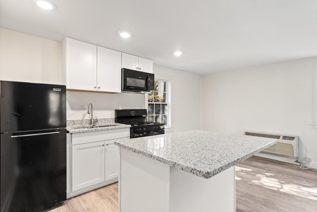3310 East Roxboro Road Northeast Atlanta, GA 30324 - Photo 41 of 47 a kitchen with granite countertop a sink stainless steel appliances and white cabinets