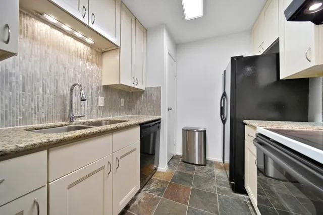 a kitchen with stainless steel appliances granite countertop a refrigerator and a sink