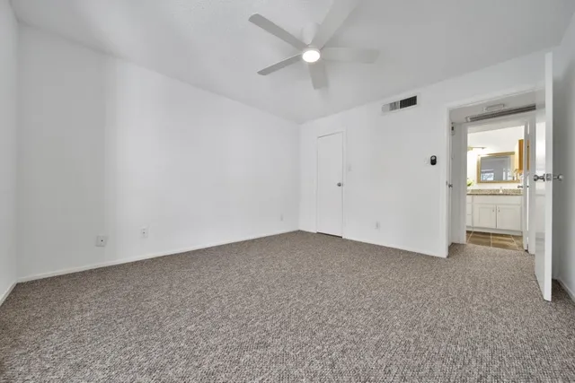 an empty room with a window and a kitchen