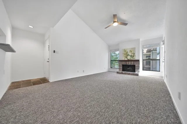 an empty room with fireplace and a window